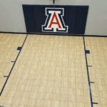 Custom design indoor basketball court by Millz House featuring SnapSports athletic tile flooring with a custom wall bad and wall mount hoop