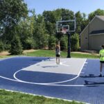 Outdoor basketball court featuring SnapSports athletic game tiles in dark blue and gray