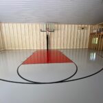 50' x 34' indoor game court featuring floor coating in white knight gray with red lane, black game lines